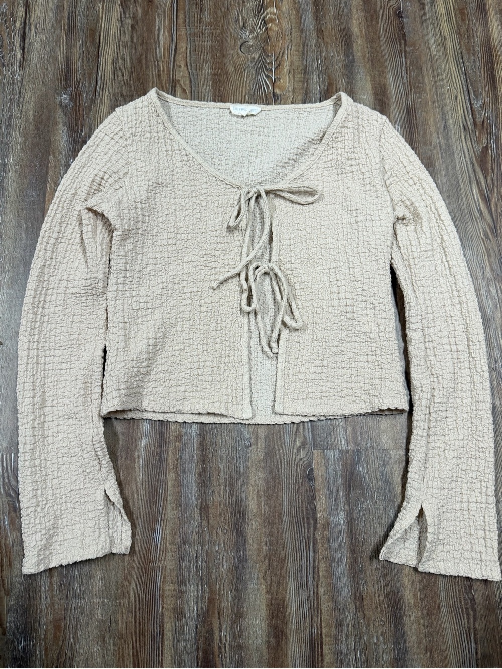Tan cropped long sleeve blouse with tie front detail and textured crinkled fabri